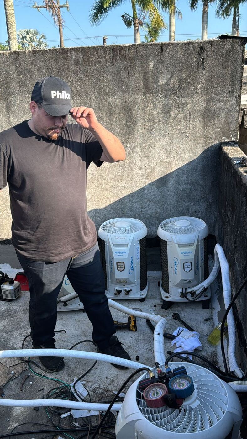 Técnico da ARTEC com condensadoras Midea instaladas em uma laje