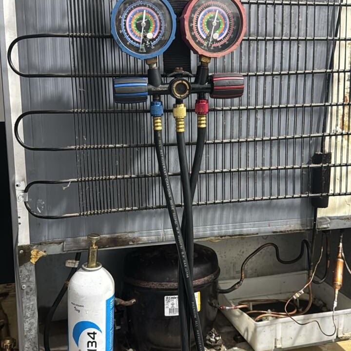 Manifold conectado ao compressor de uma geladeira em conserto