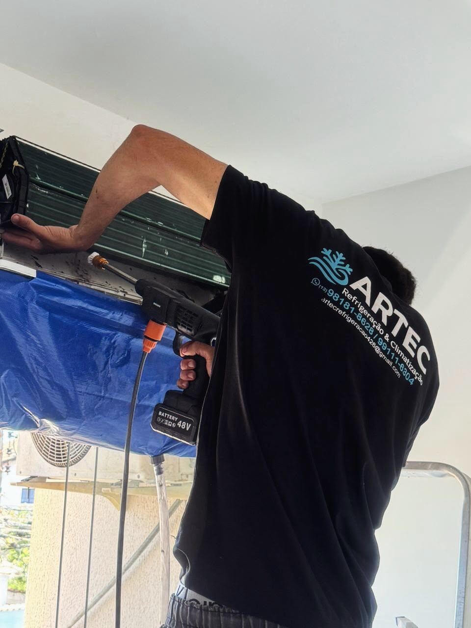 Técnico da ARTEC higienizando um ar condicionado split