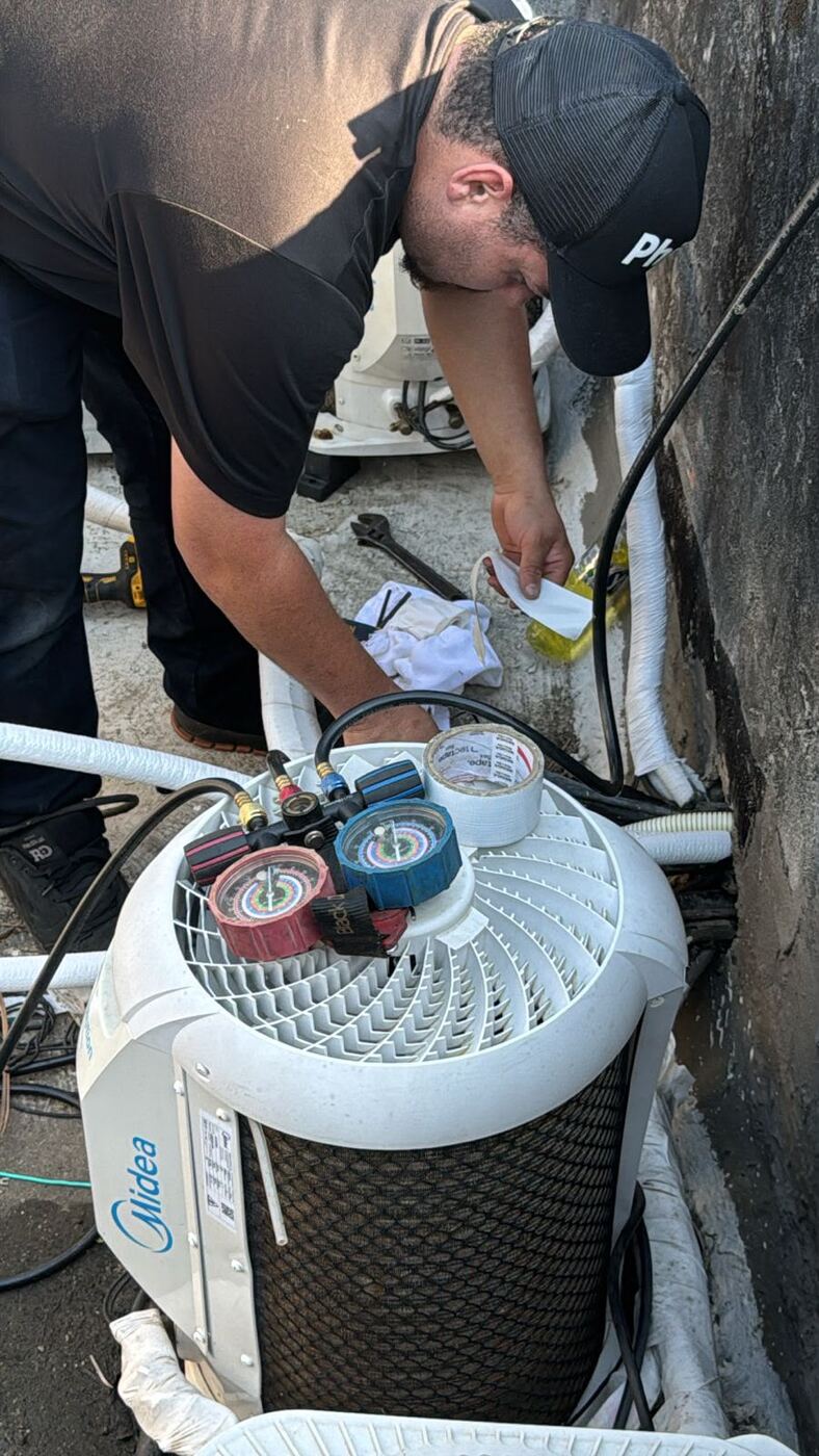 Técnico conferindo pressão com manifold em condensadora Midea